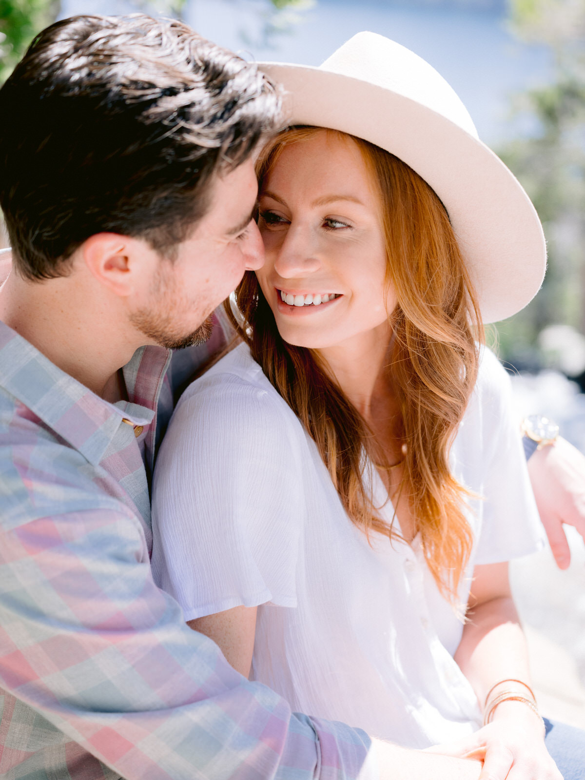 How to pick an engagement session location. Couple cuddling and smiling at one another.