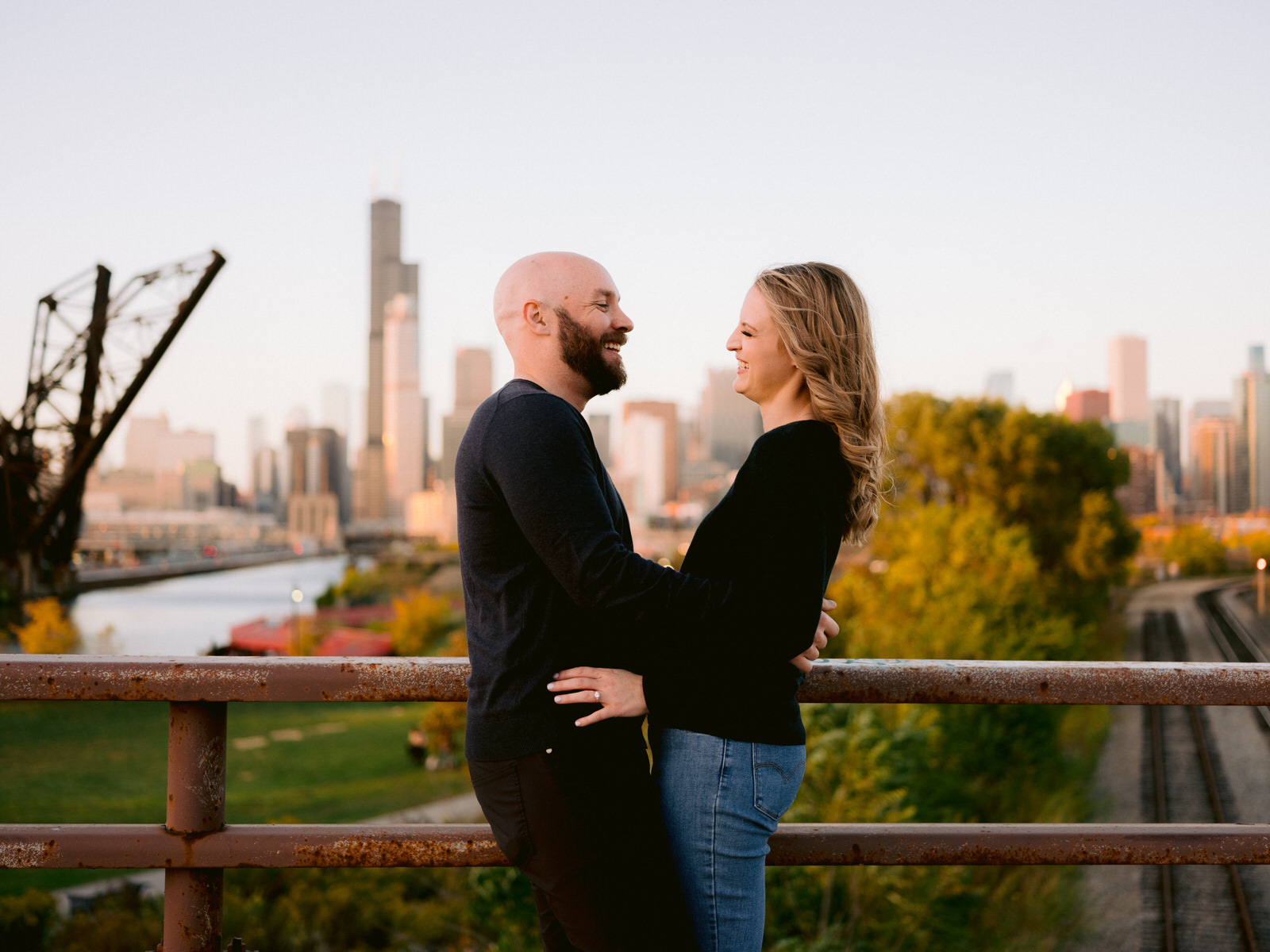 ping tom memorial park engagement photos couple laughing with one another over looking the Chicago skyline