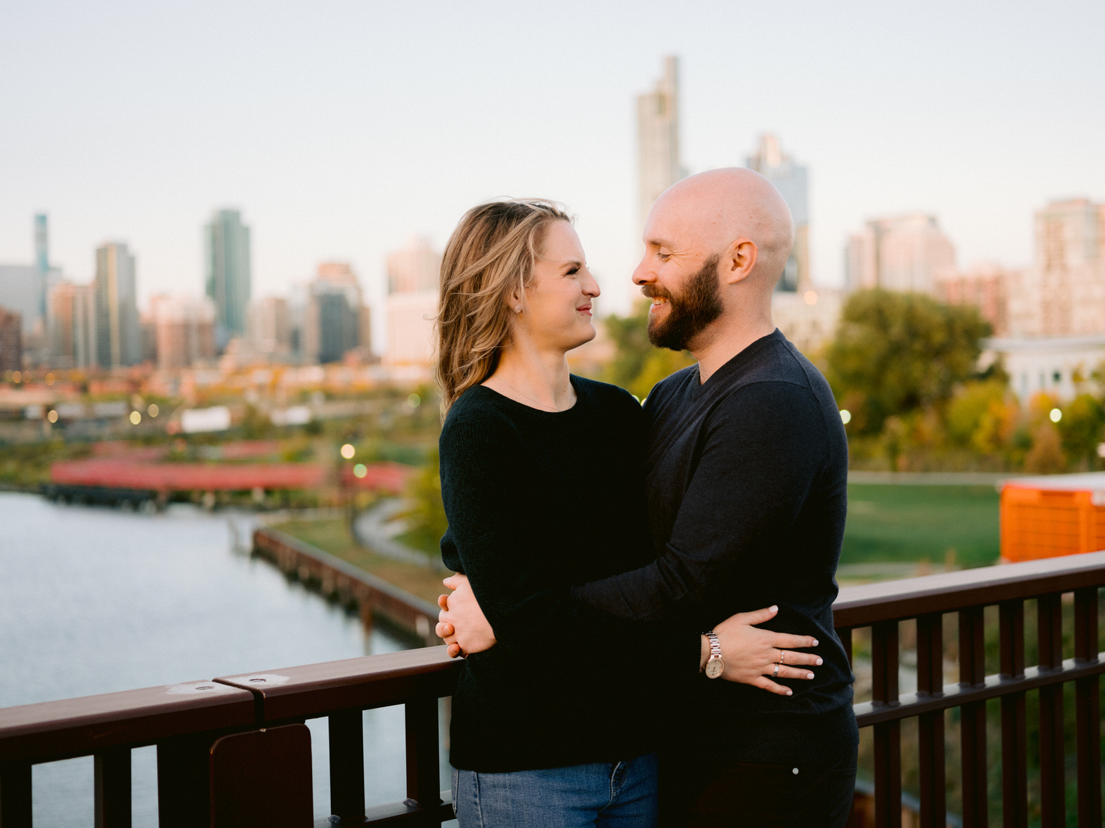 ping tom memorial park engagement photos couple smiling at one another with Chicago skyline in background