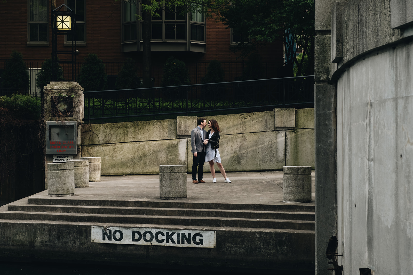 Couple standing on the dock at the Chicago Riverwalk for Chicago engagement session locations. Photography by Michael & Kristin Photo and Video