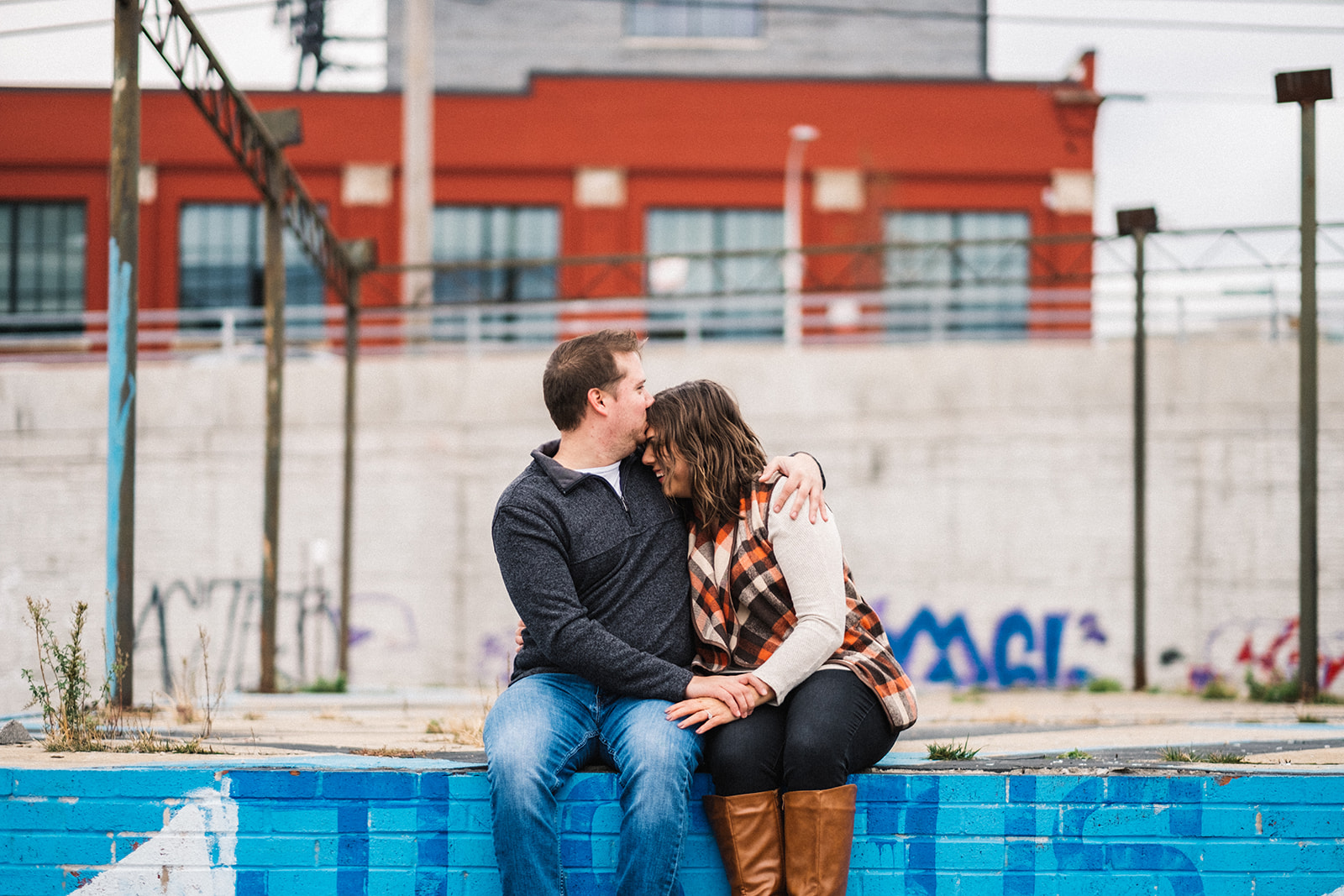 Couple sitting in front of the El in Chicago's West Loop Neighborhood for Chicago engagement session locations. Wedding photography by Michael & Kristin Photo and Video